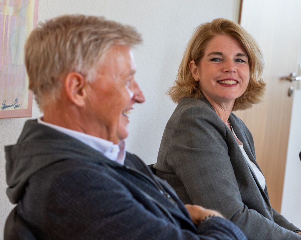 Claudia Kalisch und Ole von Beust sitzen nebeneinander und lachen